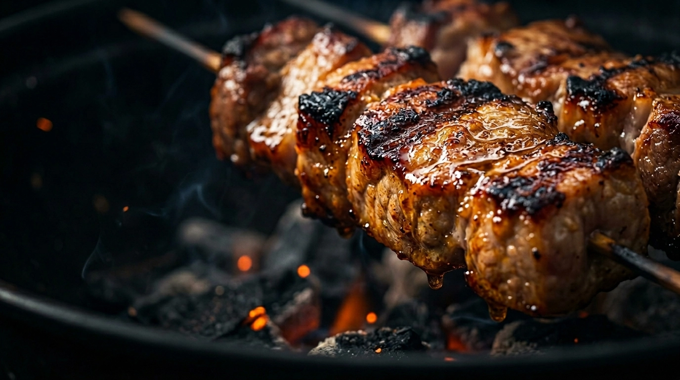 Juicy charred pork sticks on a hot grill